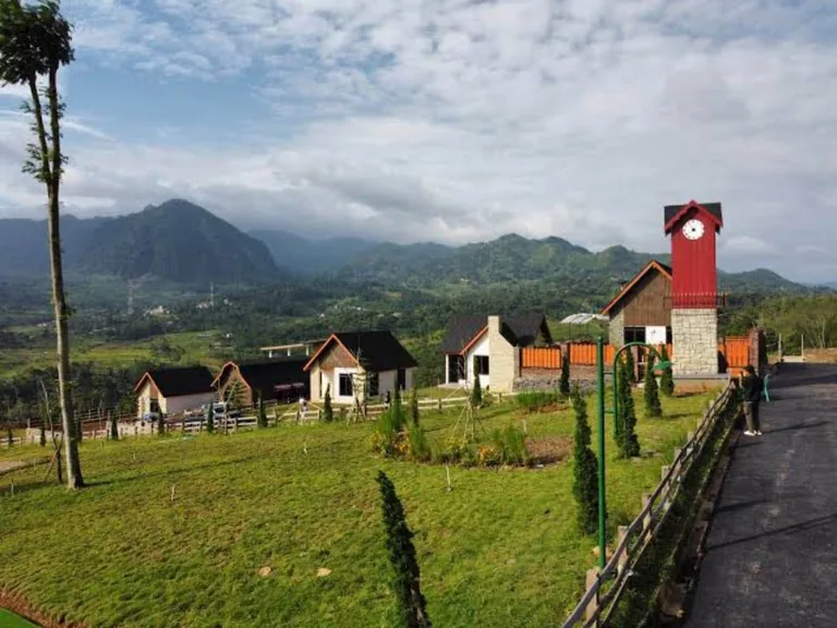 Jalan internal, taman dan menara jam warna merah pada foto dokumentasi The Hanjawong Villas.